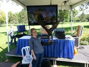 A Bald Eagle spreads its wings at Tee it up for the Troops 2013. A unit from the Minnesota National Guard in Afghanistan is on the big screen TV. The TV screen glare looks bad in this picture but was not a problem for the live audience. 